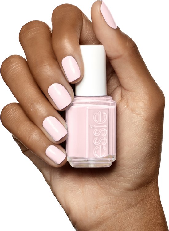 Donkere hand met zachtroze Essie nagellak.
