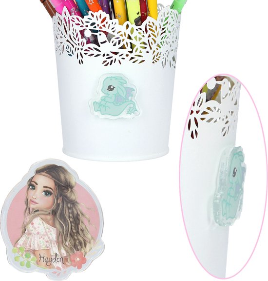 Pot blanc avec un autocollant de dragon turquoise et un autocollant du mannequin Hayden sur fond rose.