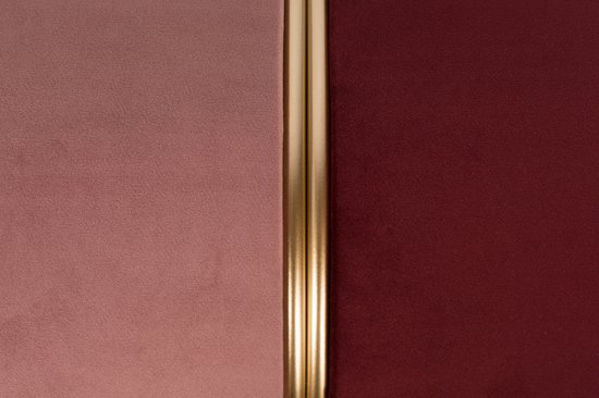 Close-up van een tweekleurige poef met roze en donkerrode stof, gescheiden door een gouden band.