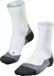 Paar Falke witte sportsokken met neongele accenten en grijze en zwarte details bij hiel en teen.