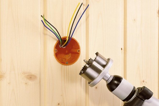 Gatenzaag met gekartelde tanden op een boor naast een open elektrische doos met draden.
