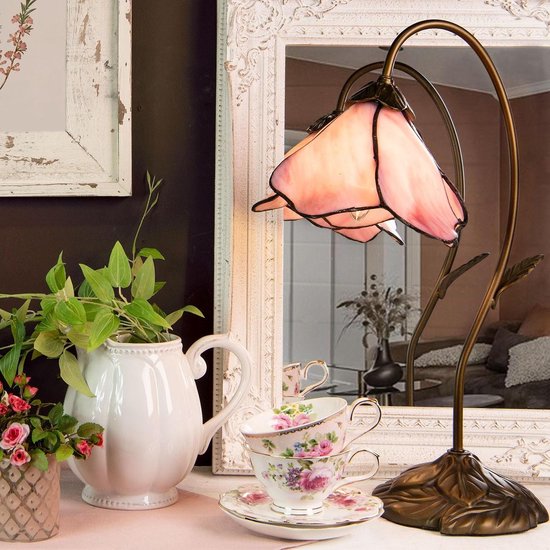 Lampe de table Tiffany rose avec abat-jour floral et base en bronze, près d'un miroir antique et de tasses.