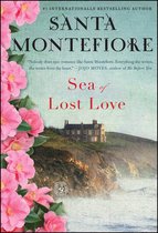 Boekcover 'Sea of Lost Love' van Santa Montefiore met roze bloemen en een huis op een klif.