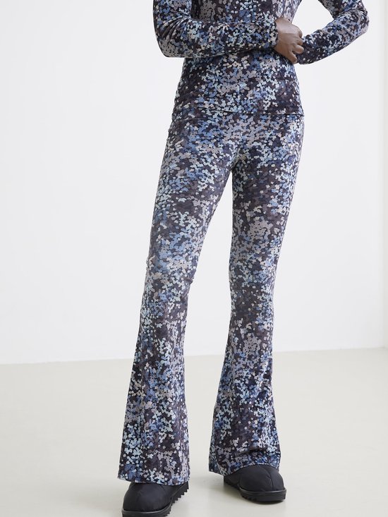 Onderlichaam van een model met een flared broek met een print van blauwe, grijze en lichtblauwe 'wolkjes'.