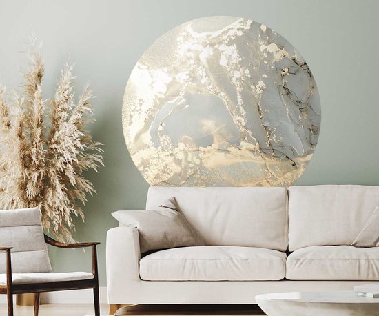 Muurcirkel met acrylverf in grijs, goud en champagne. Abstracte marmerlook, hangt boven een bank.