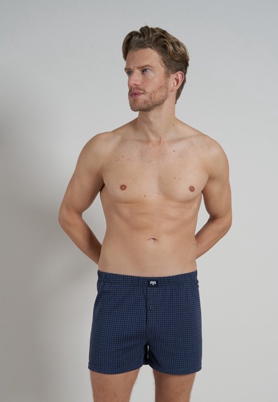 Man draagt een donkerblauwe boxer met pied-de-poule patroon en knoopjes.