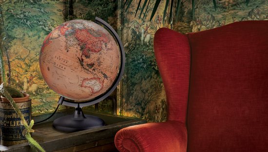 Verouderde wereldbol in een kamer met rode fauteuil en behang met paarden.