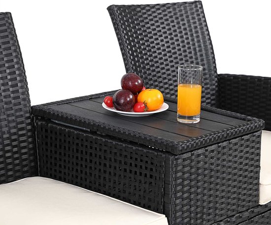 Zwarte polyrattan bank met tafel in het midden met daarop een schaal fruit en een glas jus.