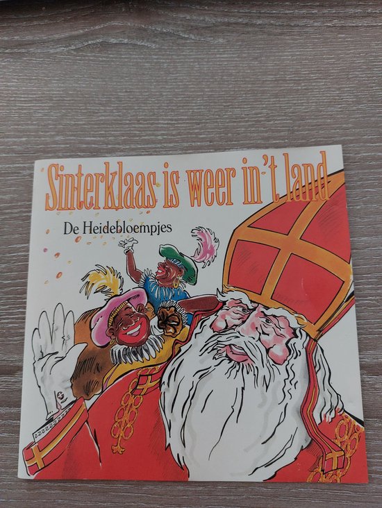 Boekomslag met Sinterklaas, zijn paard en Pieten. Tekst: Sinterklaas is weer in 't land.