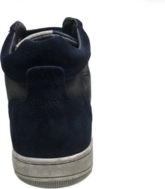 Achterkant van een donkerblauwe leren sneaker met suède accenten en een grijze zool.