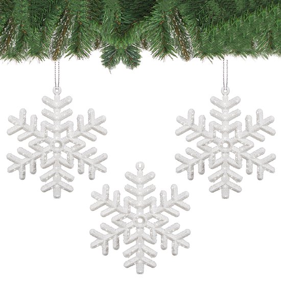Drie witte, glitterende sneeuwvlok kersthangers onder dennentakken.