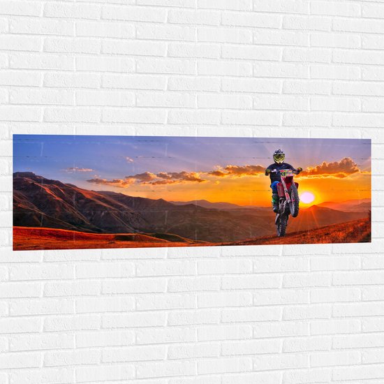 WallClassics - Muursticker - Motorrijder bij Berglandschap met Zon - 150x50 cm Foto op Muursticker
