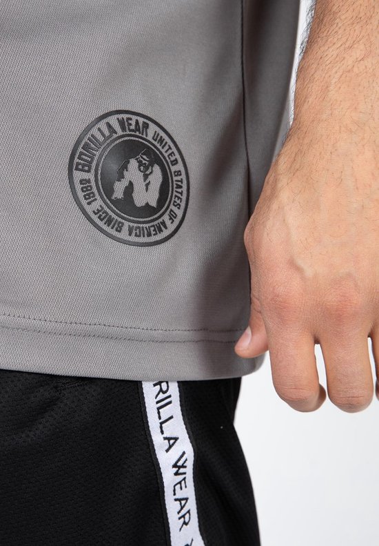 Detail van een grijze jersey met rond zwart logo 'Gorilla Wear United States of America'.