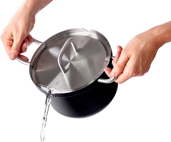 Handen die een zwarte kookpan met RVS deksel vasthouden terwijl water wordt afgegoten.