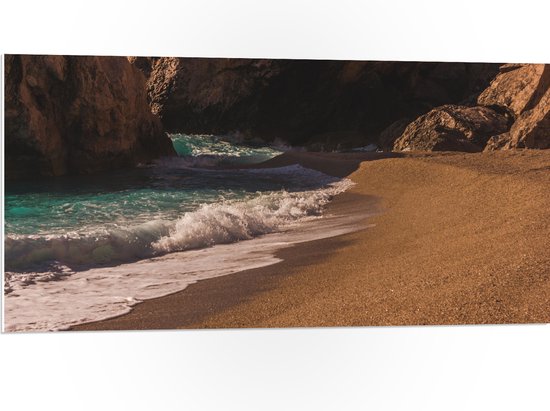WallClassics - PVC Schuimplaat- Aanspoelende Golven op Strand met Rotsen - 100x50 cm Foto op PVC Schuimplaat