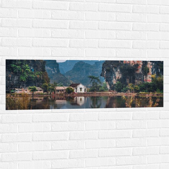 WallClassics - Muursticker - Huisje bij Water en Bergen - Vietnam - 120x40 cm Foto op Muursticker