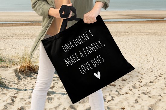 MuchoWow® Schoudertas - Strandtas - Big Shopper - Boodschappentas - Engelse quote "DNA doesn't make a family, love does" met een hartje op een zwarte achtergrond - 45x45 cm - Katoenen tas