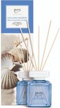 Deux diffuseurs ipuro bleus avec coquillages, sable et bâtonnets. Texte : ipuro sunny beachtime.