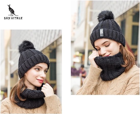 Zwarte gebreide muts met pompon en bijpassende col, gedragen door een vrouw.