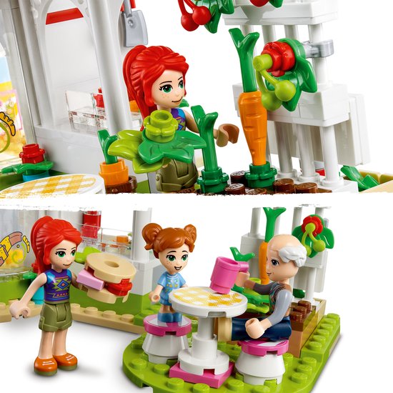 LEGO Friends café-scène met figuren die groenten oogsten en aan tafel zitten.