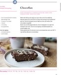 Chocoflan dessert op een grijs bord, bestrooid met sesamzaadjes en zonnebloempitjes.