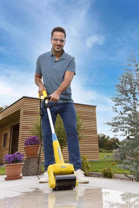 Man met veiligheidsbril gebruikt gele Gloria Multibrush op een betegeld terras.