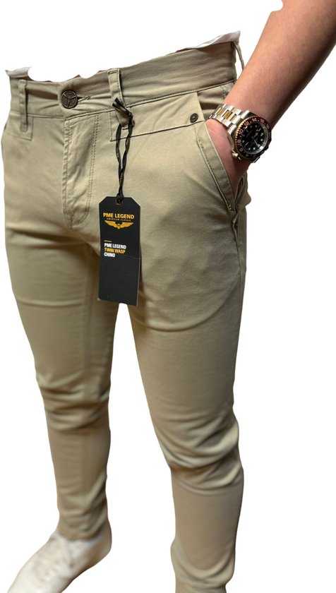 Beige chino broek van PME Legend met label, gedragen door een man. Dichtbij detail van de zak.