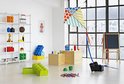 Lichte kamer met speelgoed, waaronder LEGO blokken, een vlieger en een whiteboard.