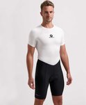 Man van voren gezien, draagt een witte fietsjersey met Rogelli logo en zwarte fietsbroek met Rogelli logo.
