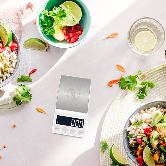 Witte keukenweegschaal met zilverkleurig weegoppervlak, display met '0.00', omringd door ingrediënten.