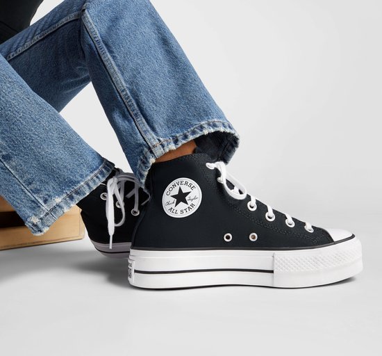 Zwarte Converse All Star Lift Hi damessneakers met witte zolen en veters, gedragen met spijkerbroek.