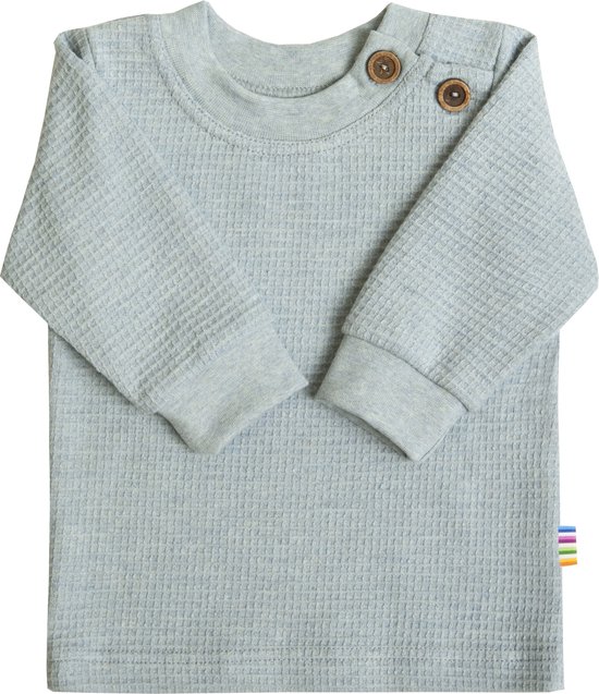 Lichtblauwe wafel gebreide longsleeve met twee houten knopen bij de hals en een regenbooglabel.