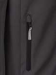Close-up van een verticaal ritsvak op een grijze softshell jas met Bjørnson-logo trekker.