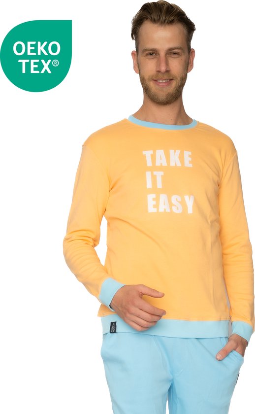 Man in een zachtoranje pyjamashirt met lichtblauwe boorden en opdruk 'TAKE IT EASY'.