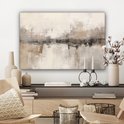 Tableau abstrait dans des tons beige, gris et brun avec texture visible, accroché au-dessus d'une commode avec des décorations.