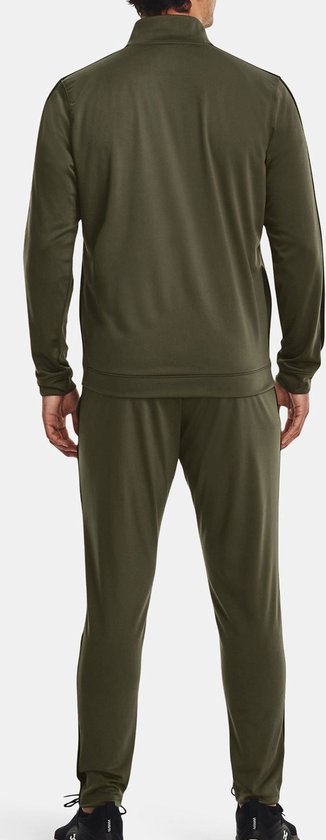 Achterkant van een man met een groen Under Armour trainingspak. Zwarte strepen op de mouwen en zijkanten van de broek.