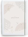 De voorkant van een geboorteboek met een neutraal, abstract ontwerp met bloemen en bladeren.