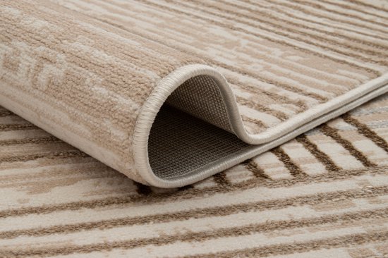 Beige en bruin vloerkleed met streepjespatroon en opgerolde hoek.