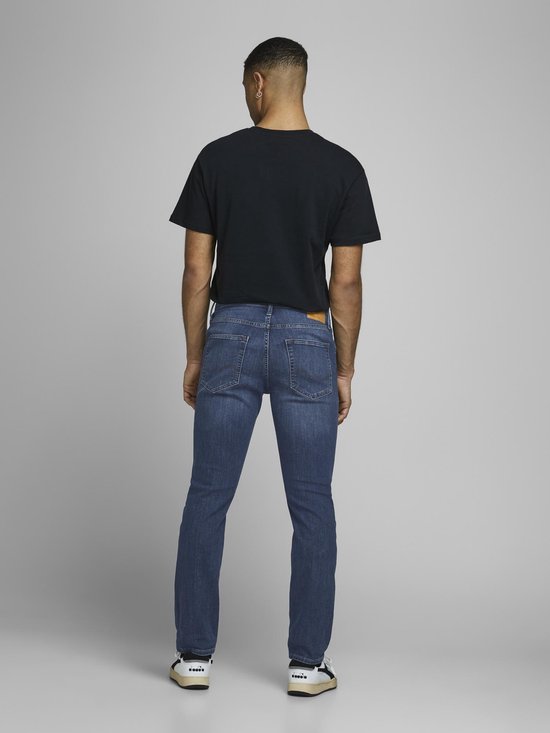 Man met spijkerbroek en zwart t-shirt, van achteren gezien.
