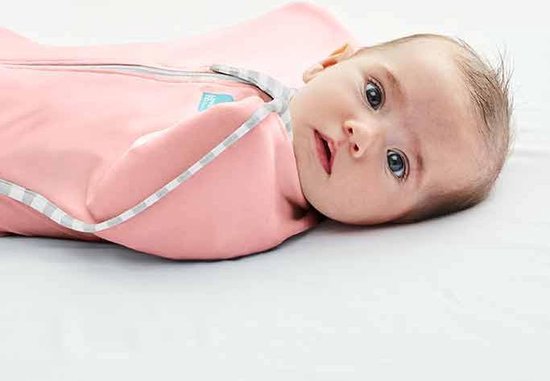 Baby met blauwe ogen in een roze Love to Dream™ Swaddle Up™ inbakerdoek, liggend op de zijkant.