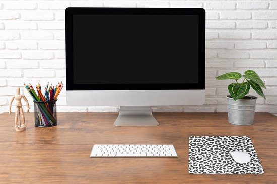 Bureau met computer, toetsenbord, muis en muismat met zwart-witte panterprint.