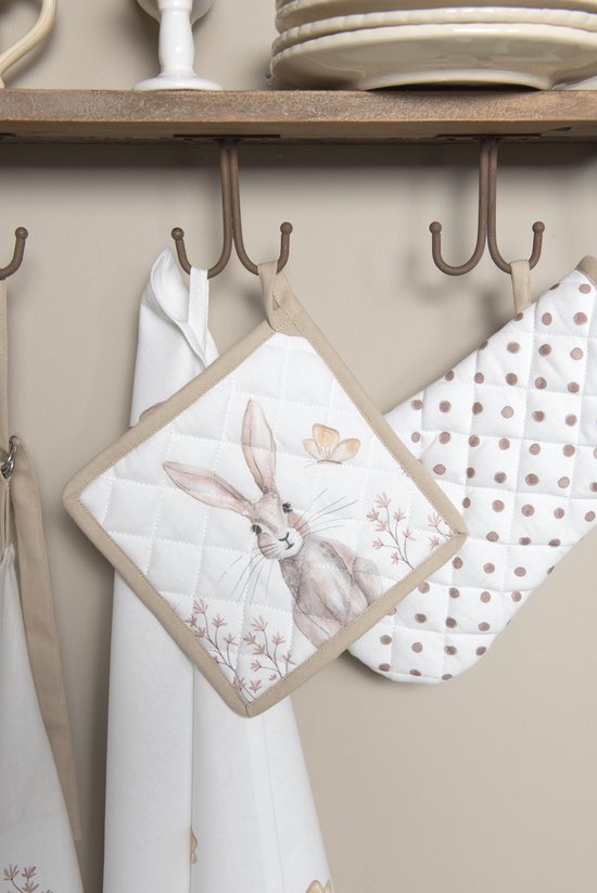 Manique blanche matelassée avec imprimé de lapin et papillon marron, accrochée à un crochet, à côté d'une manique à pois.