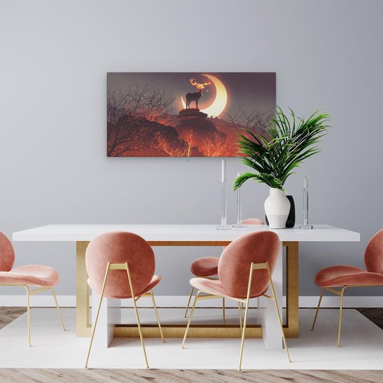 Tableau sur toile d'un cerf sur un rocher devant un croissant de lune enflammé, accroché au-dessus d'une table à manger.