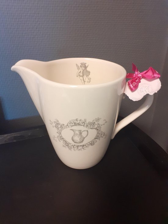 Crèmekleurige melkkan met een roze strikje en een decoratie van een engeltje en een sierschrift.