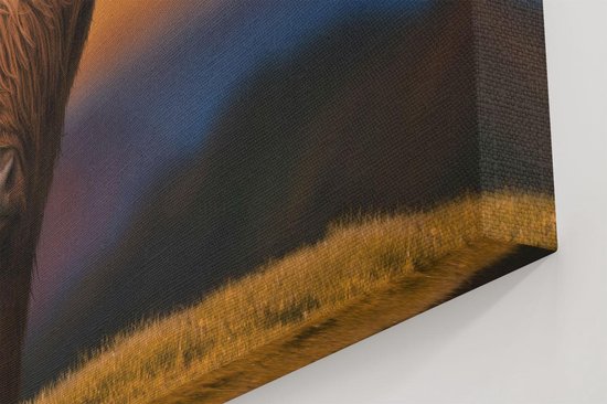 Impression sur toile d'une vache écossaise highland à longues cornes, assise sur une colline au coucher du soleil. L'arrière-plan est un paysage vallonné avec un ciel orange, bleu et violet.
