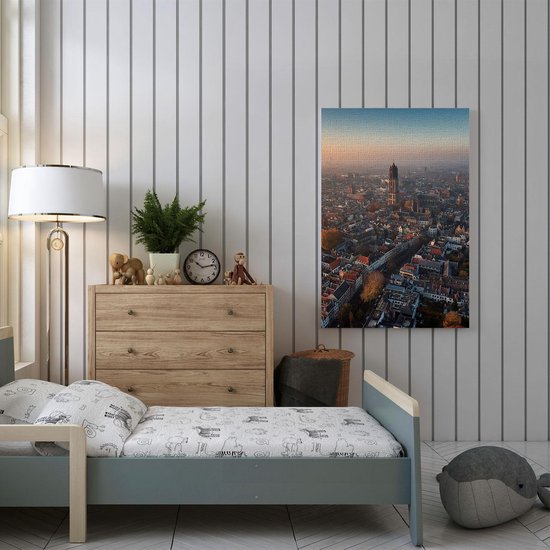 Une peinture de la skyline d'Utrecht au lever du soleil, avec la tour Domtoren bien visible. Le ciel est teinté d'orange et de bleu, et la ville est enveloppée de brume.