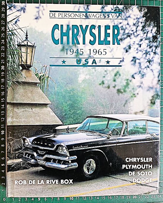 Een zwarte Chrysler uit 1955 met chroomdetails staat buiten naast een stenen muur.