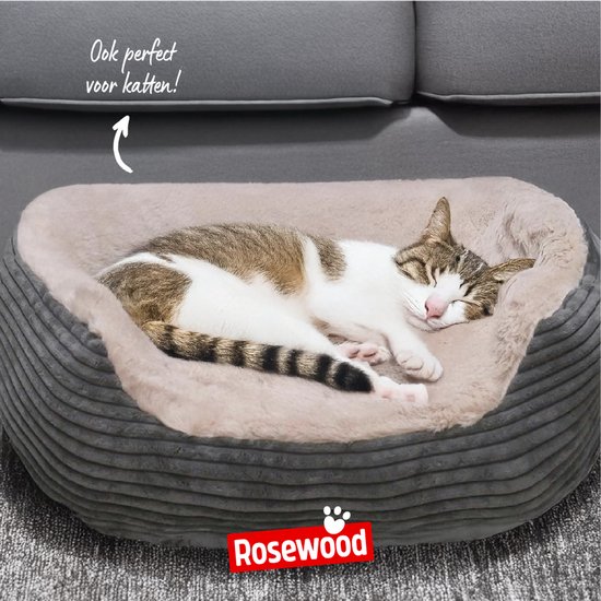 Een slapende kat in een grijze, ovale hondenmand met zachte crème binnenkant.