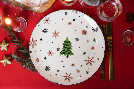 Wit bord met kerstboomprint, omringd door rode en zwarte sneeuwvlokken en rode stippen.