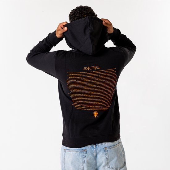 Zwarte hoodie van de achterkant met oranje tekst en het Nederlandse leeuw embleem, man trekt capuchon recht.
